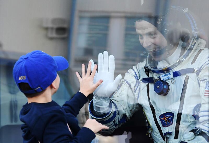 Nick Hague goes hand to hand with a child prior to the launch. EPA