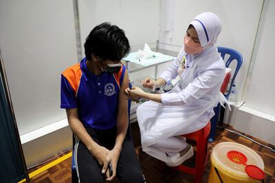 A secondary school pupil receives a dose of the Pfizer vaccine at a school, in Putrajaya, Malaysia, on September 20, 2021. Photo: Reuters