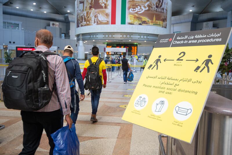 Passengers at Kuwait international airport in Kuwait City. The government said there were no plans to close the country's main airport or impose a curfew. Photo: EPA