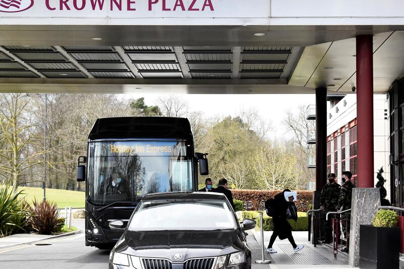 FILE PHOTO: A passenger covers her face after getting off a designated quarantine bus at Crowne Plaza Dublin Airport Hotel, as Ireland introduces hotel quarantine programme for 'high-risk' countries' travellers, in Dublin, Ireland March 26, 2021. REUTERS/Clodagh Kilcoyne/File Photo