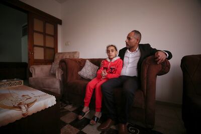 Palestinian Riad Ishkontana, 43, with his 8-year-old daughter Suzy, at the family home in Gaza City, where his family members were killed during an Israeli bombing of a residential complex in Gaza City on May 16, 2021 and 4 of his sons and his wife were killed, as the Civil Defense rescued him and his daughter from Under the rubble of a destroyed house. Photo by Majd Mahmoud / The National