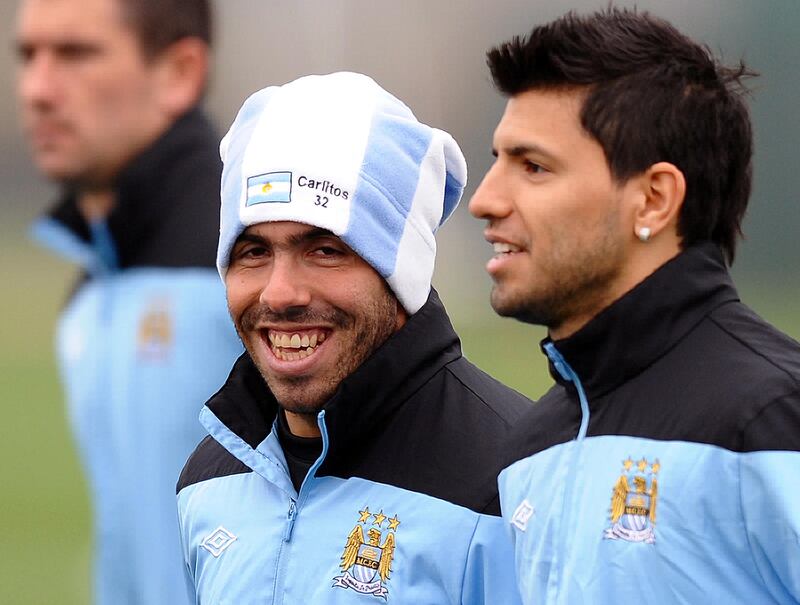 Manchester City's Argentinian footballer Carlos Tevez (C) talks to compatriot Sergio Aguero (R) during a team training session in Manchester, on March 14, 2012 ahead of their UEFA Europa League Round of 16 second leg football match between Manchester City and Sporting Lisbon on March 15, 2012. AFP PHOTO/PAUL ELLIS