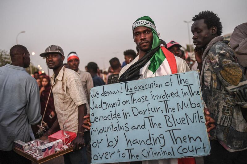 TOPSHOT - A Sudanese protestor holds a placard during a protest outside the army complex in the capital Khartoum on April 20, 2019.  Protest leaders are to hold talks today with Sudan's military rulers who have so far resisted calls to transfer power to a civilian administration, two leading figures in the protests told AFP. / AFP / OZAN KOSE
