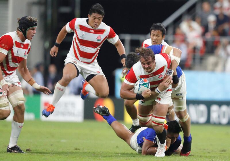 Japan's James Moore, right, is tackled at the City of Toyota Stadium. Associated Press