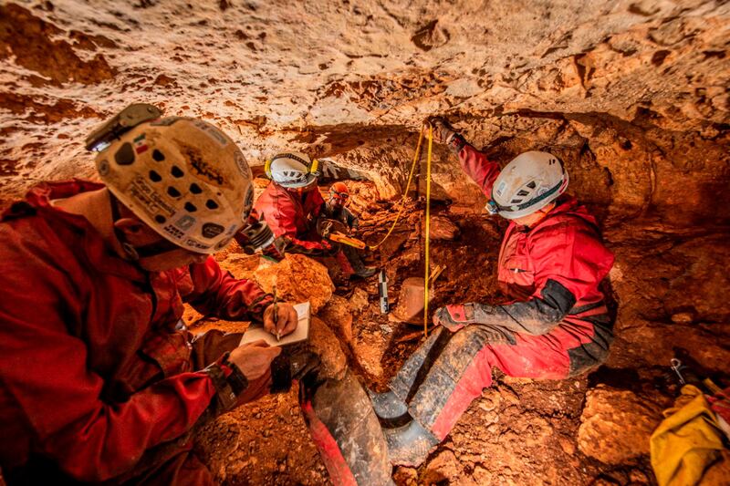 Archaeologists take measurements at the site where they found pottery amid the construction of a controversial tourist train, in the state of Yucatan.