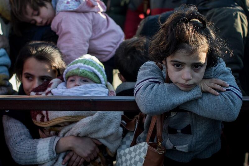 A girl waits to cross a border gate as a small number of Syrian refugees are allowed to return to Syria at the closed Turkish border on February 8, at Kilis. More than 35,000 refugees have amassed at the border after fleeing Russian air strikes and the regime offensive around the city of Aleppo. Chris McGrath / Getty Images
