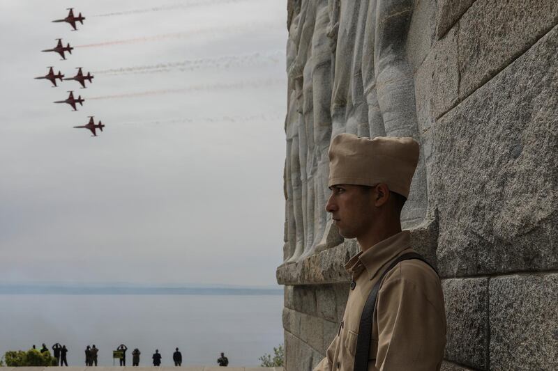 A Turkish soldiers, dressed in a WWI military uniform attends the international service in recognition of the Gallipoli campaign, as aircrafts of the Turkish army aerobatic demonstration team, perform over the Mehmetcik monument in the Gallipoli peninsula. AP