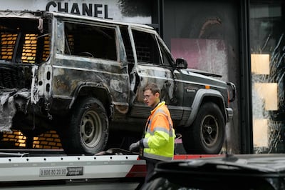 A man removes the wreckage of a vehicle that was used by robbers to ram into a Chanel boutique, near the Champs-Elysees in Paris, in a separate theft. AFP 
