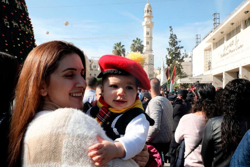 A woman carries a child in front of the Church of the Nativity in the biblical city of Bethlehem in the occupied West Bank. AFP
