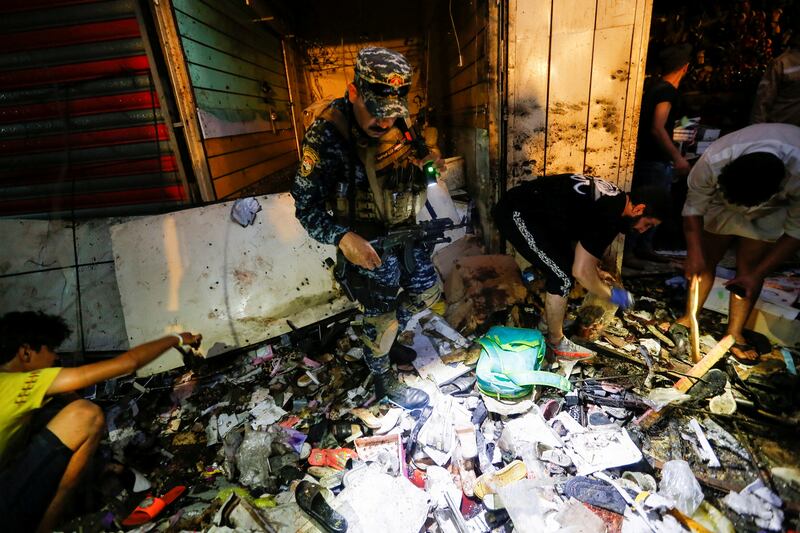 A member of the Iraqi security forces inspects the site of an explosion in the Sadr City district of Baghdad, Iraq.