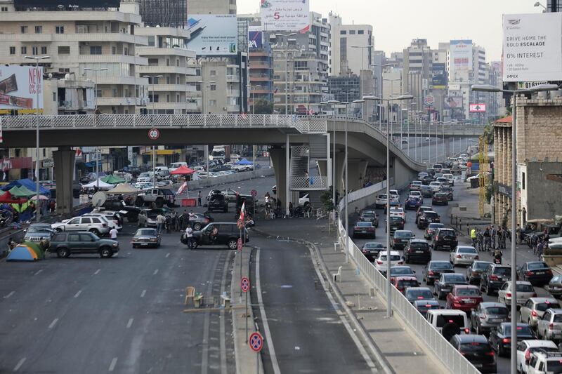 Cars, right, are stuck in a traffic jam as anti-government protesters, left, block a highway that links the capital Beirut to northern Lebanon by cars, tents, stones and bricks during a protest against the Lebanese government in the town of Jal El Dib north of Beirut, Lebanon. AP Photo