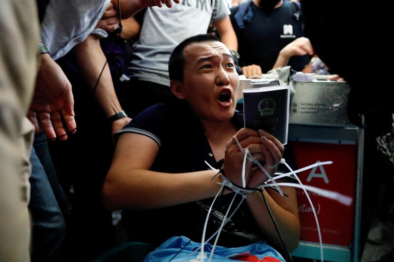 Fu Guohao, a reporter with Chinese media Global Times website, is tied up by protesters during a mass demonstration at the Hong Kong international airport. Reuters