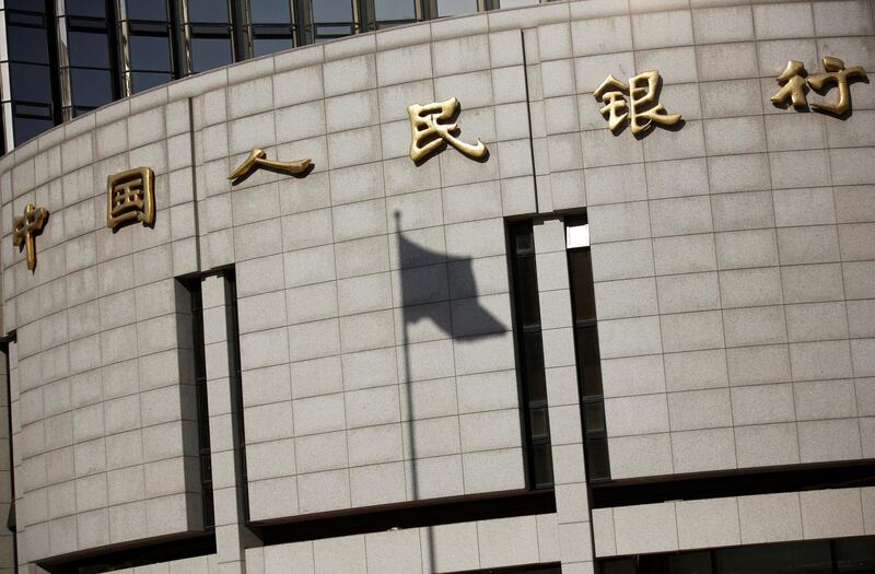 FILE PHOTO: A fluttering Chinese national flag casts its shadow on the headquarters of China's central bank, People's Bank of China (PBOC), in central Beijing, China November 24, 2014.    REUTERS/Kim Kyung-Hoon/File Photo