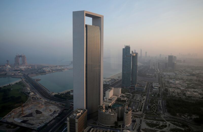 The sun rises over Adnoc headquarters in Abu Dhabi. The energy company wants to achieve net-zero emissions by 2045. AP