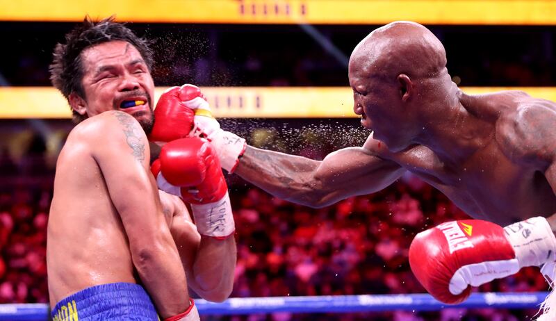Manny Pacquiao takes a punch from Yordenis Ugas. AFP