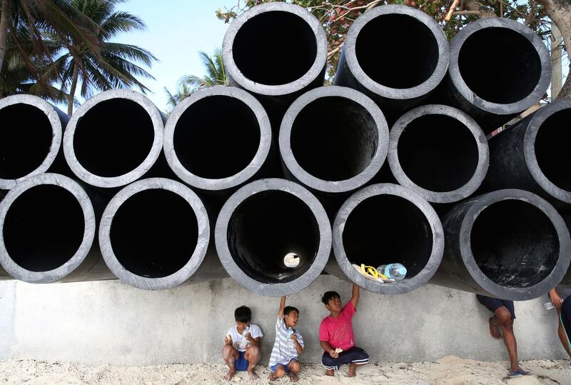 Young residents sit underneath drainage pipes as the government implements the temporary closure of the country's most famous beach resort island of Boracay on Thursday, April 26, 2018. Aaron Favila / AP Photo