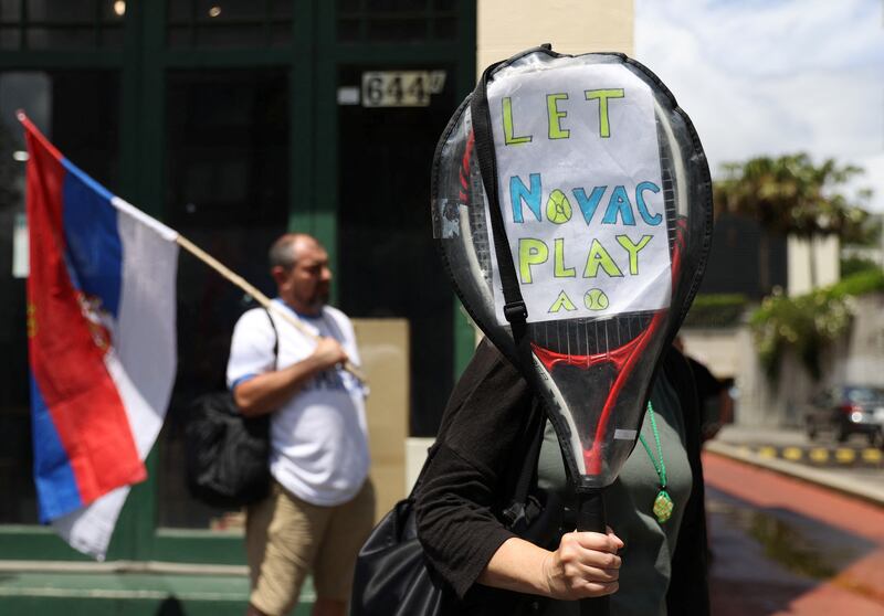 A supporter of Serbian tennis player Novak Djokovic holds up a sign outside the Park Hotel. Reuters