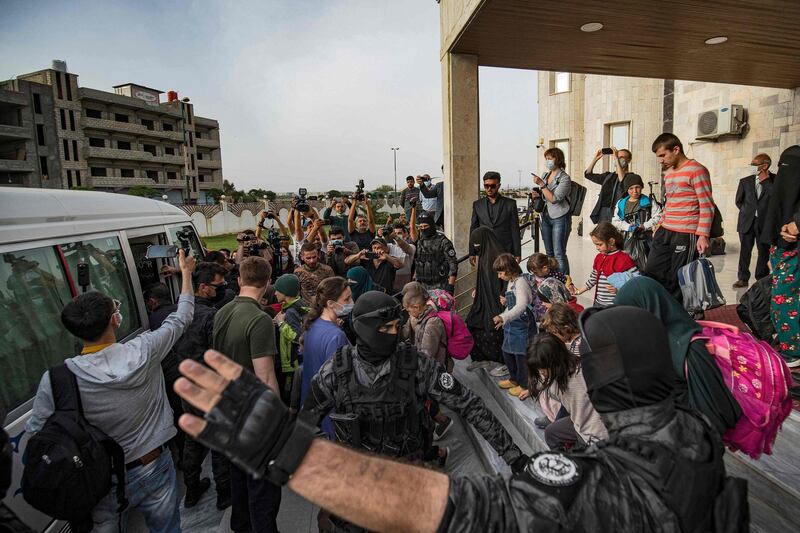 Children prepare to board a bus during the handover of orphans of suspected ISIS fighters to a Russian delegation by Syrian Kurdish officials in Qamishli, north-east Syria. Thirty-four children were to be repatriated. AFP