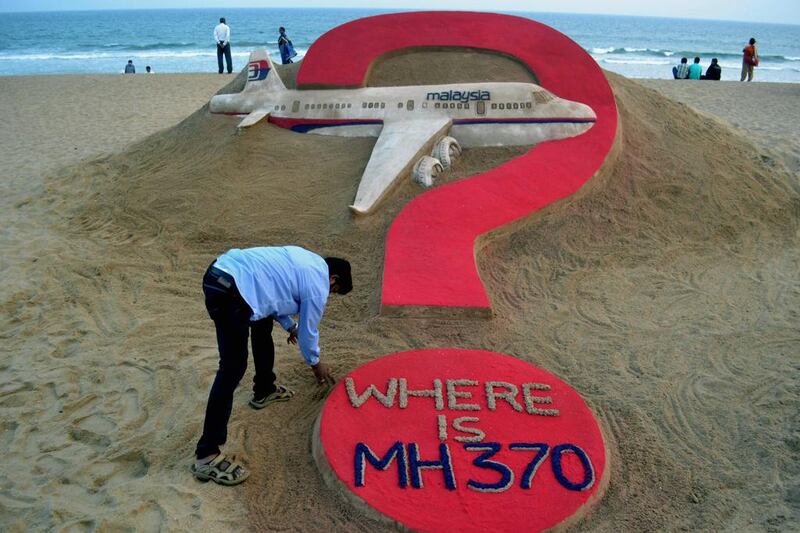 Indian sand artist Sudarsan Pattnaik creating a sand sculpture of the missing Malaysian airliner MH370 on Puri beach in eastern Odisha state.  JK Jagdev / AFP

