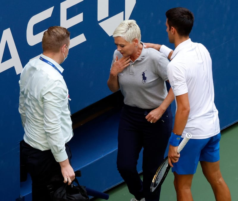 Novak Djokovic tries to help  the line judge. EPA