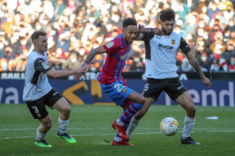 Barcelona's Pierre-Emerick Aubameyang vies with Valencia defenders Toni Lato and Omar Alderete at the Mestalla stadium in Valencia. AFP.