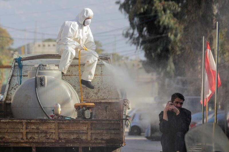 A municipal worker sprays disinfectant in the suburb of Beir Hassan, Beirut. AP Photo