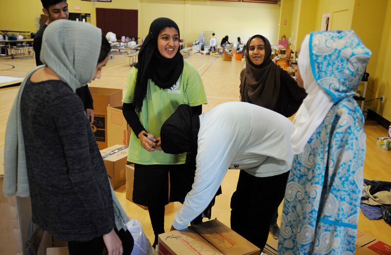 In this Thursday, Aug. 31, 2017, photo, volunteers with the Islamic Society of Greater Houston, package donations at a mosque that was being used as a shelter. Houston's Muslim community, an estimated 200,000 people, has opened many of its community centers and sent hundreds of volunteers to serve food and deliver donations. Some have rescued neighbors from high water. (AP Photo/Jay Reeves)