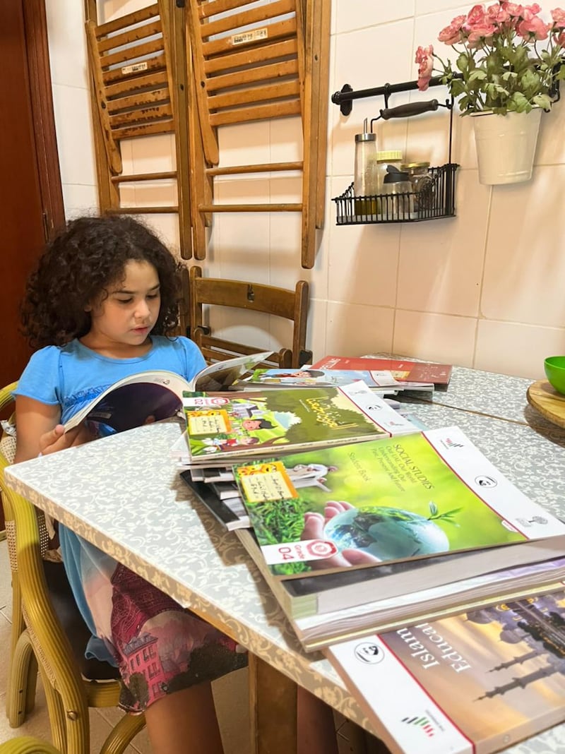 Nora Younis's daughter, who will move to grade four next year, taking a look at books shared by another parent. Photo: Nora Younis