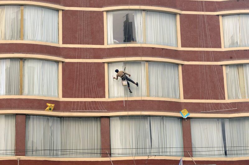 An Indian window cleaner cleans a window of a hotel in Amritsar. AFP