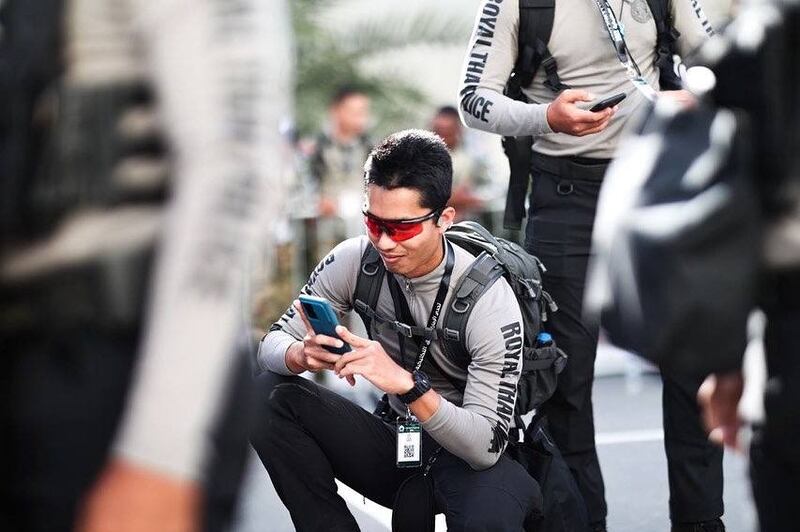 A member of the Royal Thai Police checks his mobile phone during break time at the UAE Swat Challenge 2022. 
