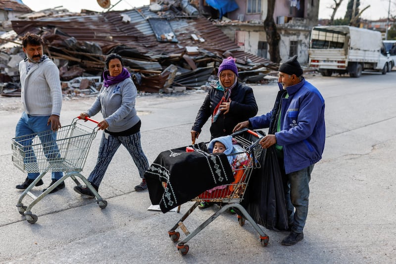 Earthquake survivors walk on a street in Hatay, Turkey. Reuters