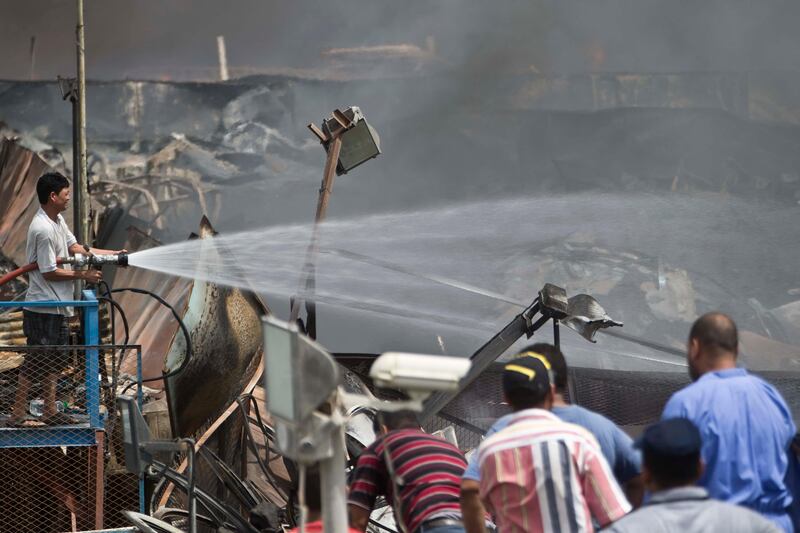 SHARJAH, UNITED ARAB EMIRATES,  AUGUST 12, 2013. A fire rages through a car breaker/scrap yard of the Sharjah Industrial area located behing Sharjah City Center. Civilians and workers from the different car shops helped civial defense to fight the blaze. (ANTONIE ROBERTSON / The National) Journalist Yassin *** Local Caption ***  AR_1208_Sharjah_Fire19.jpg