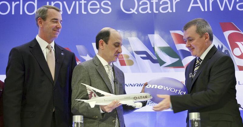The chief executive of Qatar Airways, Akbar Al Baker, centre, exchanges a gift with IAG chief, Willie Walsh, as American Airlines chief executive, Tom Horton, looks on in New York. AP Photo