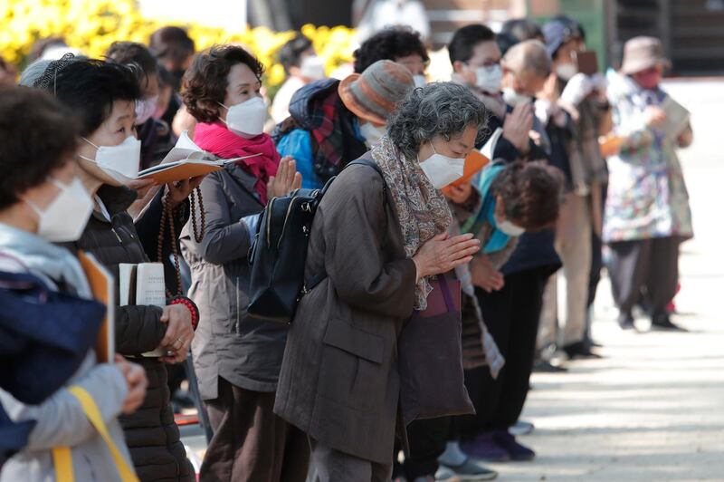 People wearing face masks to help curb the spread of the coronavirus pray during a service at the Chogyesa temple in Seoul, South Korea. South Korea on Monday began testing tens of thousands of employees of hospitals and nursing homes to prevent Covid-19 outbreaks at live-in facilities. AP Photo