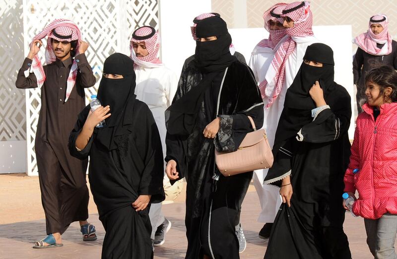 A picture taken on January 19, 2018 shows Saudi women and men walking during the King Abdulaziz Camel Festival in Rumah, some 160 kilometres east of Riyadh.
For decades the religious police, "mutawa" as they are known, wielded unbridled powers as arbiters of morality, patrolling streets and malls to snare women wearing bright nail polish and chastise men seeking contact with the opposite sex. In recent years, Saudi Arabia launched a series of reforms, including gradually diminishing the mutawa's powers to arrest. Crown Prince Mohammed bin Salman has further cut back the political role of hardline clerics in a historic reordering of the Saudi state.
 / AFP PHOTO / FAYEZ NURELDINE