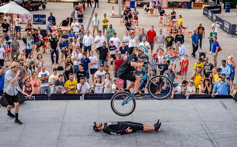 A crowd watches a biker showing his skills.