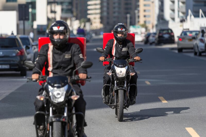DUBAI, UNITED ARAB EMIRATES, 21 APRIL 2016. A bike safety campaign called Safety Delivered where delivery drivers were asked who were important in their lives, and were given helmets with pictures of their family and words such “I am a son” and “I am a father”. The aim is to remind the drivers that they have people counting on them to be safe while they are out on the road. Sajjad Hussein (front) and Ahsan Akhbar (Back) both from Pakistan ride  with their helmets and delivery bikes. (Photo: Antonie Robertson/The National) ID: 44814. Journalist: Ramona Ruiz. Section: National. *** Local Caption ***  AR_2104_Delivery_Bike_Safety-17.JPG