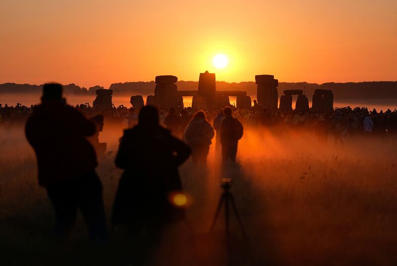People watch the sun rise, as they take part in the Summer Solstice at Stonehenge in Wiltshire, Friday, June 21, 2024.  (Andrew Matthews / PA Wire / PA via AP)