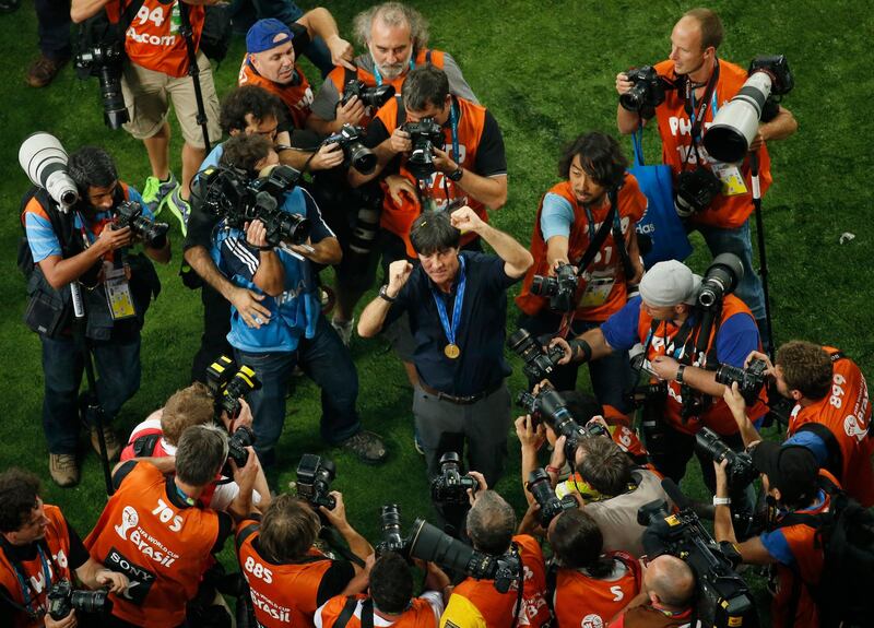 Germany's coach Joachim Loew (C) is surrounded by photographers as he celebrates his team's victory in the final football match between Germany and Argentina for the FIFA World Cup at The Maracana Stadium in Rio de Janeiro on July 13, 2014.   AFP PHOTO / FABRIZIO BENSCH/POOL (Photo by FABRIZIO BENSCH / POOL / AFP)