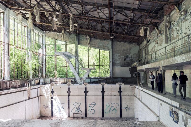 Tourists explore the decaying interior of the abandoned swimming pool complex. Bloomberg
