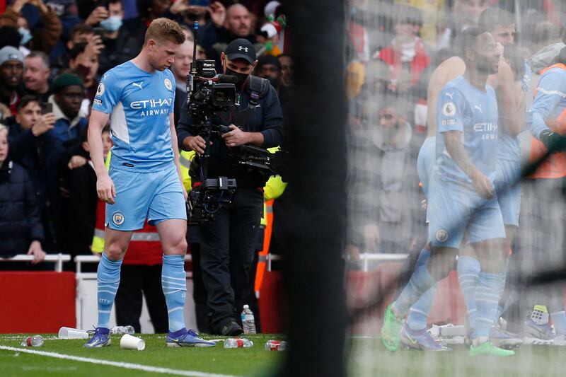 Manchester City's Belgian midfielder Kevin De Bruyne stands amid bottles and debris thrown by spectators after Rodri's winner at the Emirates Stadium on Saturday. AFP