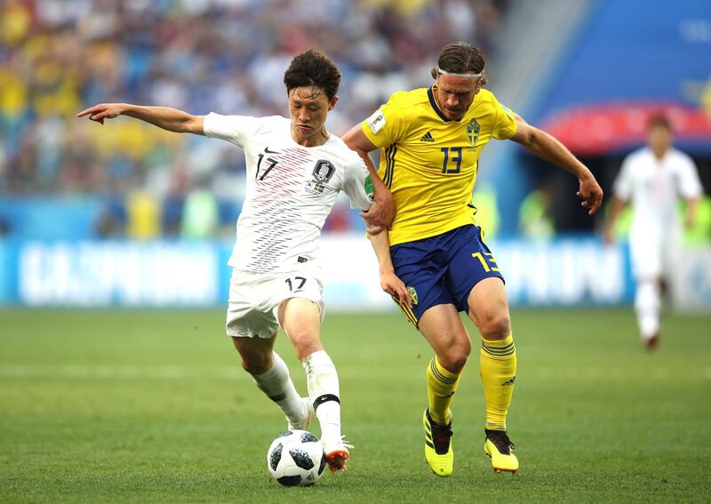 Lee Jae-Sung of South Korea challenges for the ball with Gustav Svensson of Sweden. Clive Mason / Getty Images