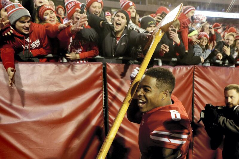 MADISON, WI - NOVEMBER 26: Corey Clement #6 of the Wisconsin Badgers celebrates with the Paul Bunyan Axe trophy after beating the Minnesota Golden Gophers 31-17 at Camp Randall Stadium on November 26, 2016 in Madison, Wisconsin.   Dylan Buell/Getty Images/AFP