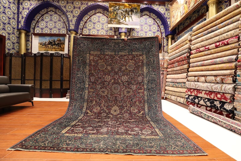 An 18th-century handmade carpet of silk and wool featuring flowers, animals and Persian calligraphy. It is priced at $1 million.