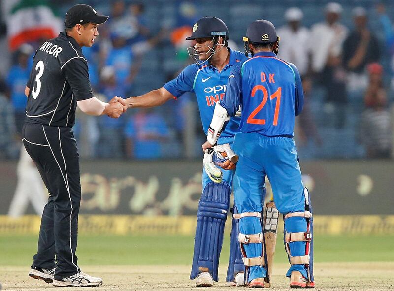 Cricket - India v New Zealand - Second One Day International Match - Pune, India, October 25, 2017 - India's Mahendra Singh Dhoni (C) shakes hands with New Zealand's Ross Taylor as Dinesh Karthik looks on after India won the match. REUTERS/Amit Dave