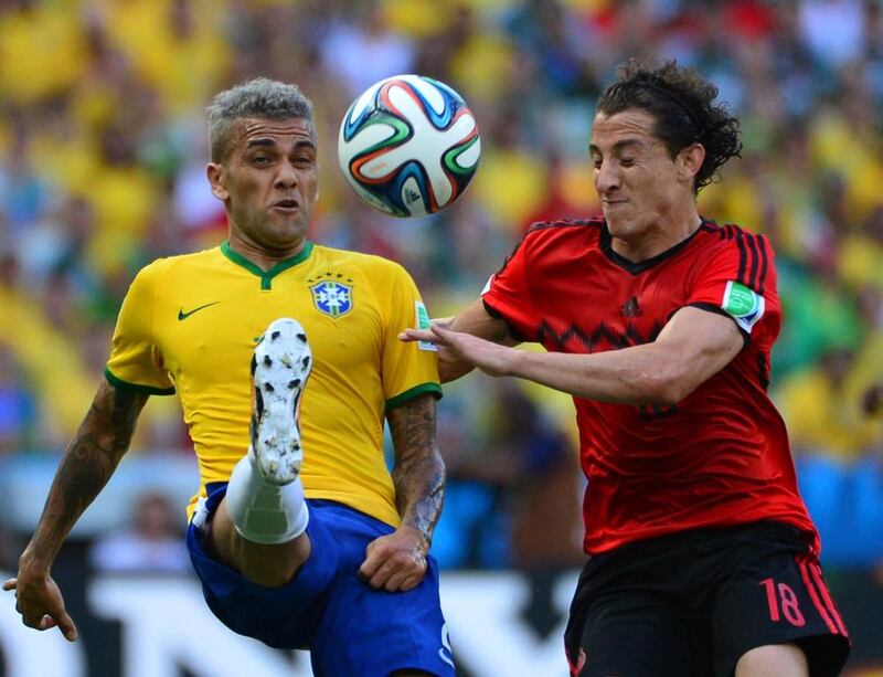 Brazil defender Dani Alves vies with Mexico defender Andres Guardado during their Group A match on Tuesday at the 2014 World Cup in Fortaleza, Brazil. Yuri Cortez / AFP
