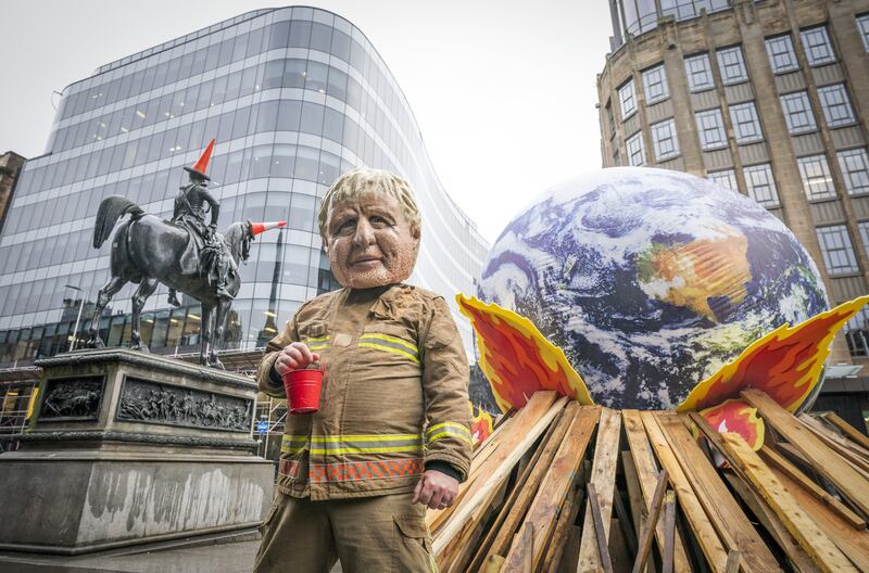 Friday protests on Day 13 of the Cop26 Summit in Glasgow – a campaigner in a Boris Johnson mask takes part in Oxfam's 'Ineffective Fire-Fighting World Leaders' protest performance. PA