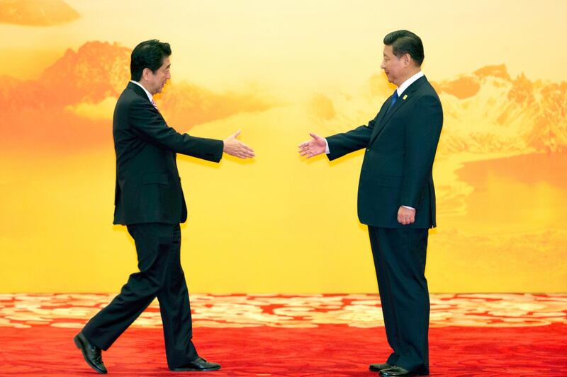 Japan's Prime Minister Shinzo Abe reaches out to shake hands with Chinese President Xi Jinping during a welcome ceremony for the Asia-Pacific Economic Cooperation (APEC) Economic Leaders Meeting in Beijing in 2014. AP Photo