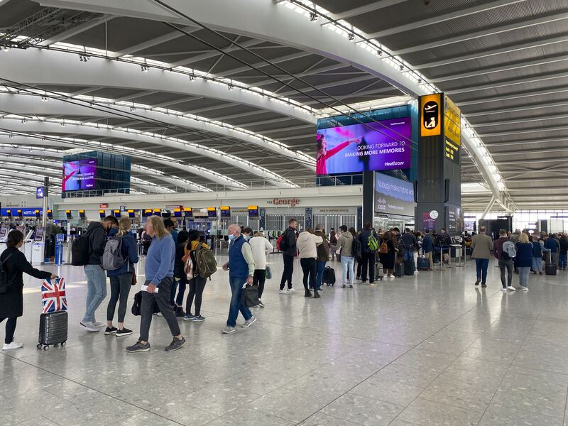 Passengers queue at Heathrow Airport. PA