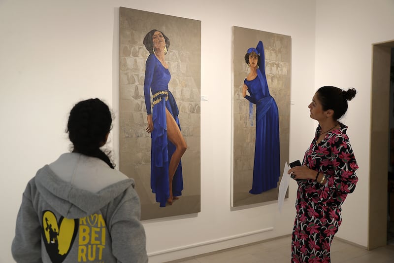 Another two stretched canvases depict dancers draped in a royal blue full-length dress